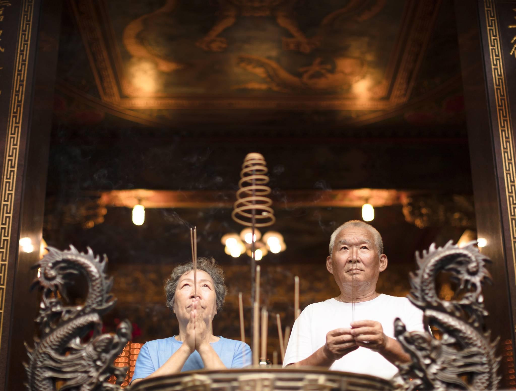 couple âgé chinois prie au temple