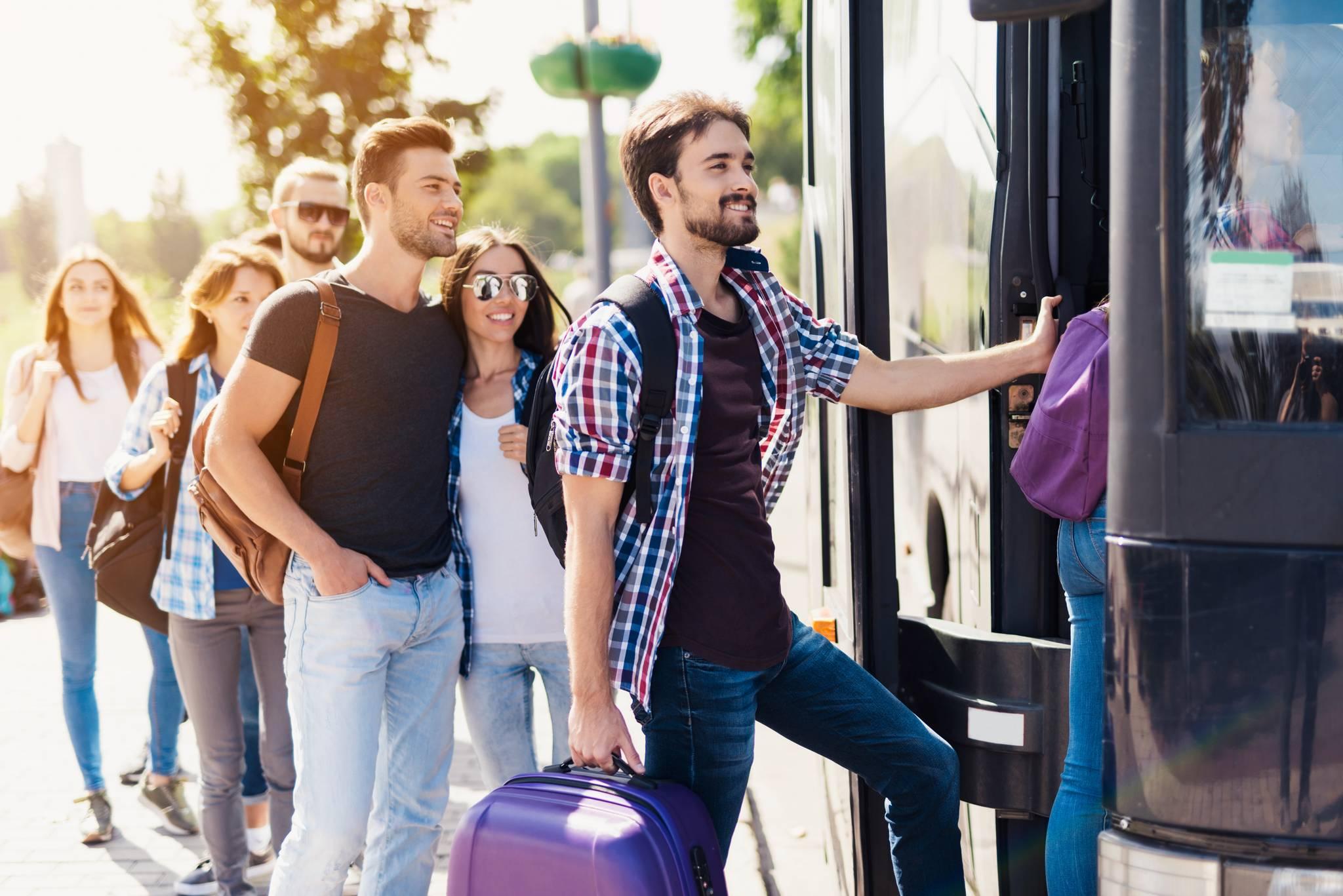 personnes montent dans un bus avec des valises