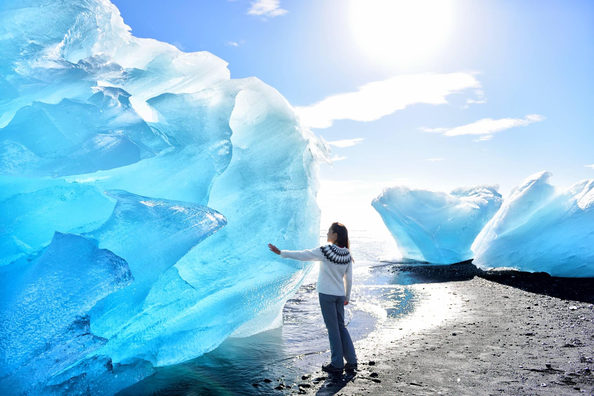 fille touchant un glacier en Islande