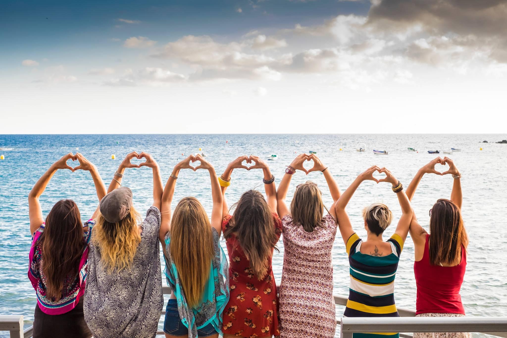 groupe de femmes devant la mer coeur avec les mains